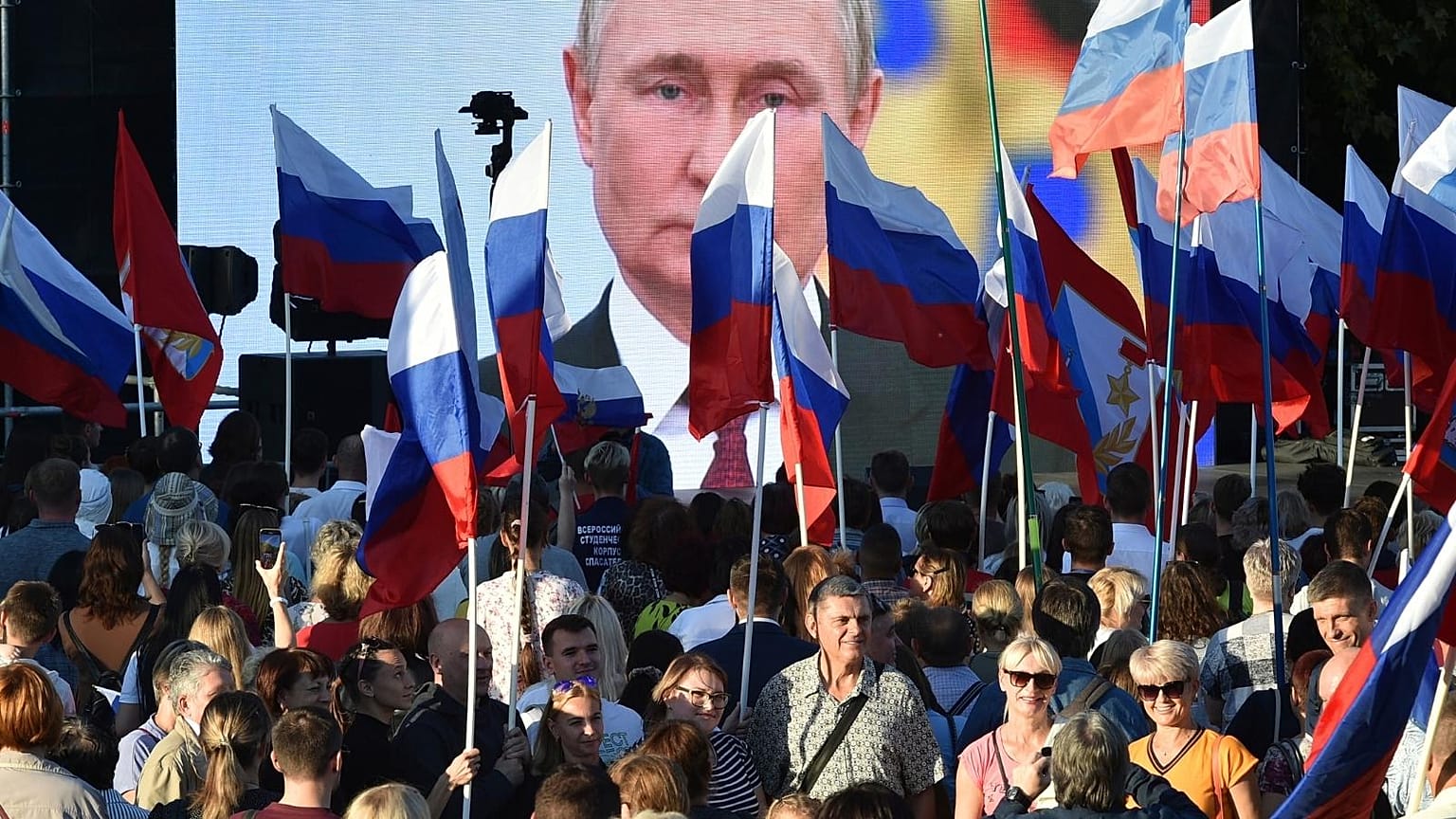 People gather in front of a large screen, to celebrate the incorporation of regions of Ukraine to join Russia in Sevastopol, Crimea, Friday, Sept. 30, 2022.