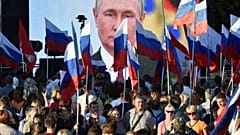 People gather in front of a large screen, to celebrate the incorporation of regions of Ukraine to join Russia in Sevastopol, Crimea, Friday, Sept. 30, 2022.