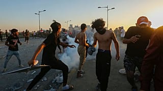 Des manifestants irakiens face aux gaz lacrymogènes lancés par les forces de sécurité à Bagdad, en Irak, samedi 1er octobre 2022.