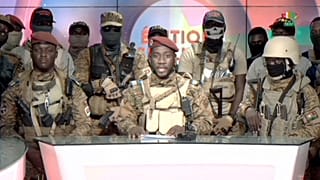 Coup spokesman Capt. Kiswendsida Farouk Azaria Sorgho reads a statement in a studio in Ougadougou, Burkina Faso, on Friday evening, Sept. 30, 2022.
