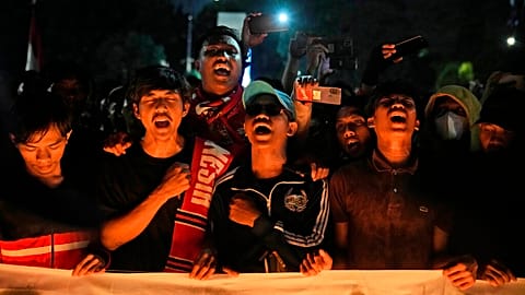 Des supporters de football à Jakarta dimanche 2 octobre 2022 lors d'une veillée d'hommage aux victimes du mouvement de foule survenu la veille à Malang. 