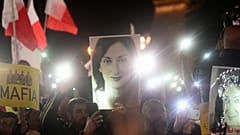 Protestors hold up a pictures of slain journalist Daphne Caruana Galizia during a demonstration outside Malta's prime minister's office in Valletta, Malta, 2019