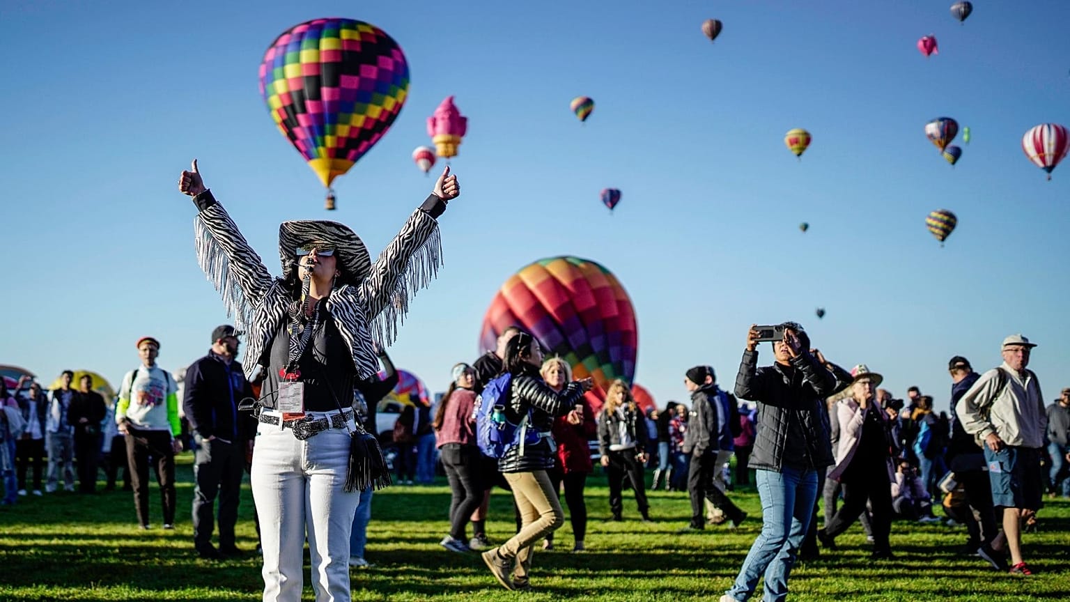 Nicole Tagart, a launch official with the 50th annual Albuquerque International Balloon Fiesta, signals a balloonist to take off. 
