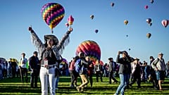 Nicole Tagart, a launch official with the 50th annual Albuquerque International Balloon Fiesta, signals a balloonist to take off. 