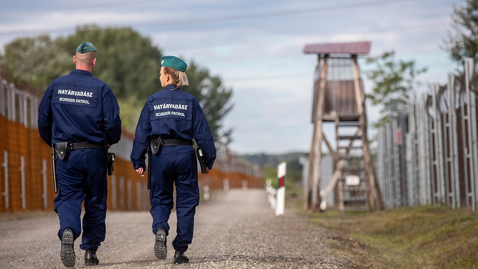 Operational police officers walk along the service route of Hungary's border with Serbia near Roszke, Southern Hungary, Wednesday, Sept. 28, 2022.