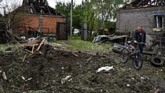 Un homme marchant près d'un cratère créé par une explosion après une attaque russe nocturne à Kramatorsk, en Ukraine, mardi 4 octobre 2022. 
