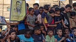 أطفال في غزة يحملون صورة للقائد السابق في حركة الجهاد الإسلامي خالد منصور الذي قتل بغارة إسرائيلية في آب/أغسطس الماضي