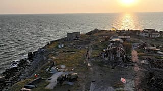 Ukrainian service members walk next to destroyed buildings, as Russia's attack on Ukraine continues, on Snake (Zmiinyi) Island, in Odesa region.