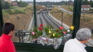 Flowers are placed on a bridge above the railway line at the spot of the train crash.