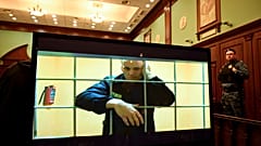 Le chef de l'opposition Alexei Navalny apparaît sur un écran installé dans une salle d'audience du tribunal municipal de Moscou via une liaison vidéo depuis sa prison