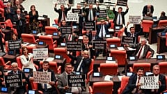 Opposition lawmakers in Turkey hold signs in protest against the new "disinformation" law.
