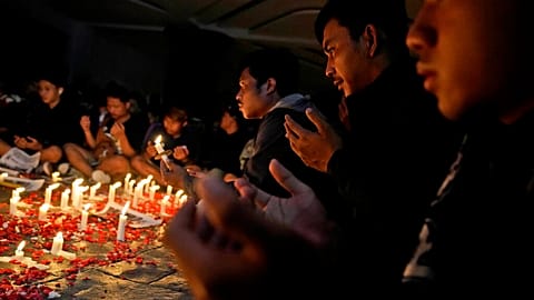 Soccer fans pray during a candle light vigil for the victims of Saturday's stampede