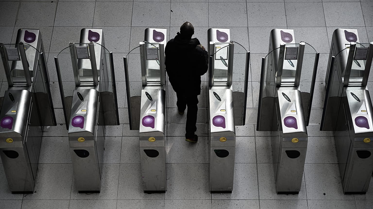 Un usager du métro passe le portique à Gare du Nord