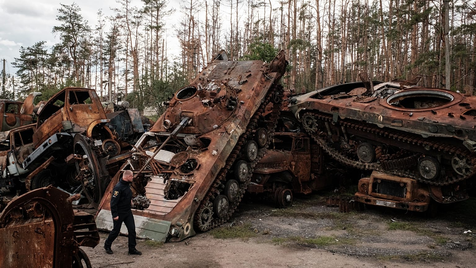 Policier ukrainien devant des carcasses de chars russes à Lyman, le 5 octobre 2022