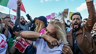 A woman cuts her hair during a protest against the death of Iranian Mahsa Amini, in Istanbul, Turkey, Sunday 2 Oct 2022.