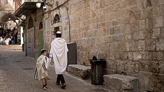 يهودي وابنه يسيران في أزقة البلدة القديمة في القدس في عيد الغفران