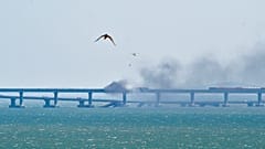 Un helicóptero lanza agua para detener el fuego en el puente de Crimea sobre el estrecho de Kerch, en Crimea, el sábado 8 de octubre de 2022
