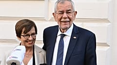 Austria's President Alexander Van der Bellen and his wife Doris speak to the media in front of a polling station in Vienna, in presidential elections on October 9, 2022.