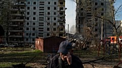 Mucola Markovitch, 76 ans essuie une larme devant un immeuble durement frappé dans la ville de Zaporijjia, Ukraine le 9 octobre 2022.