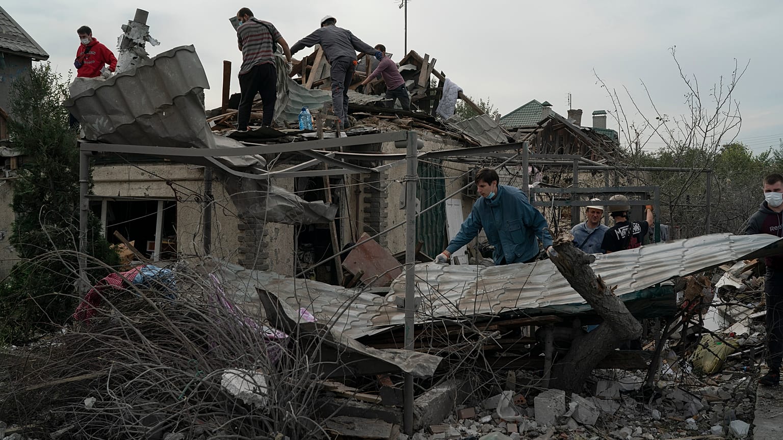 Voluntarios trabajan para limpiar los escombros después de un ataque ruso en una zona residencial en Zaporiyia, Ucrania, el domingo 9 de octubre de 2022.
