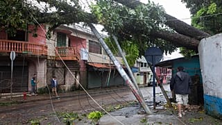 Los residentes caminan bajo los postes eléctricos rotos por los vientos huracanados de Julia en Bluefields, Nicaragua, el 9 de octubre de 2022. 