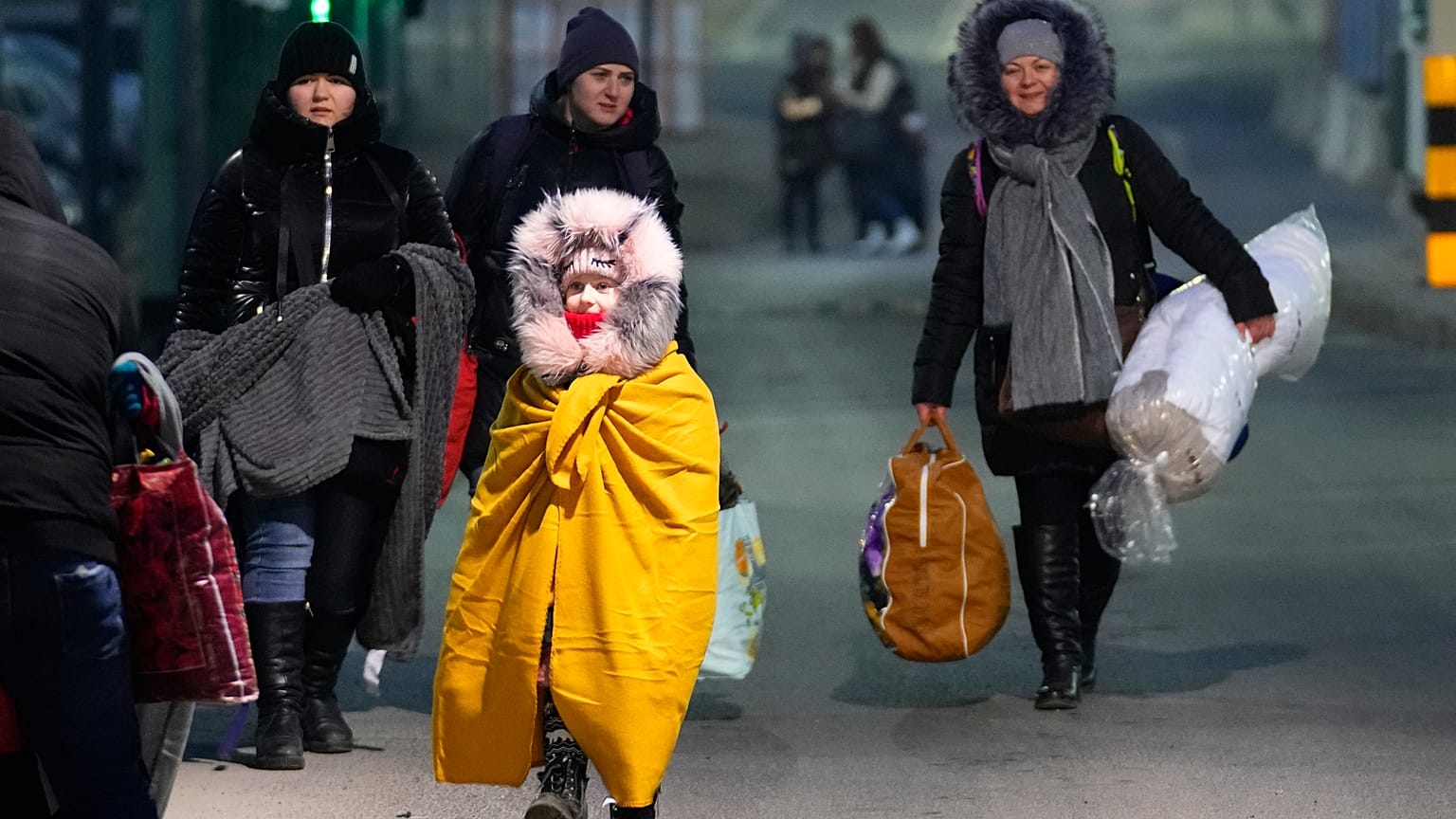 People fleeing the conflict in neighboring Ukraine cross the border in Przemysl, Poland, Feb. 27, 2022.