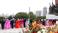 Citizens pay tribute before the statues of North Korea leaders Kim Il Sung and Kim Jong Il