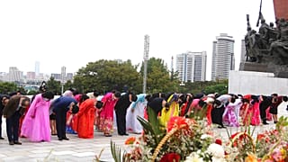 Citizens pay tribute before the statues of North Korea leaders Kim Il Sung and Kim Jong Il
