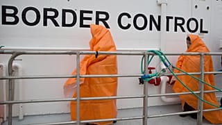 Two children disembark with other migrants and refugees from a Norwegian Frontex patrol vessel on Greek island of Lesbos, March 22, 2016. 