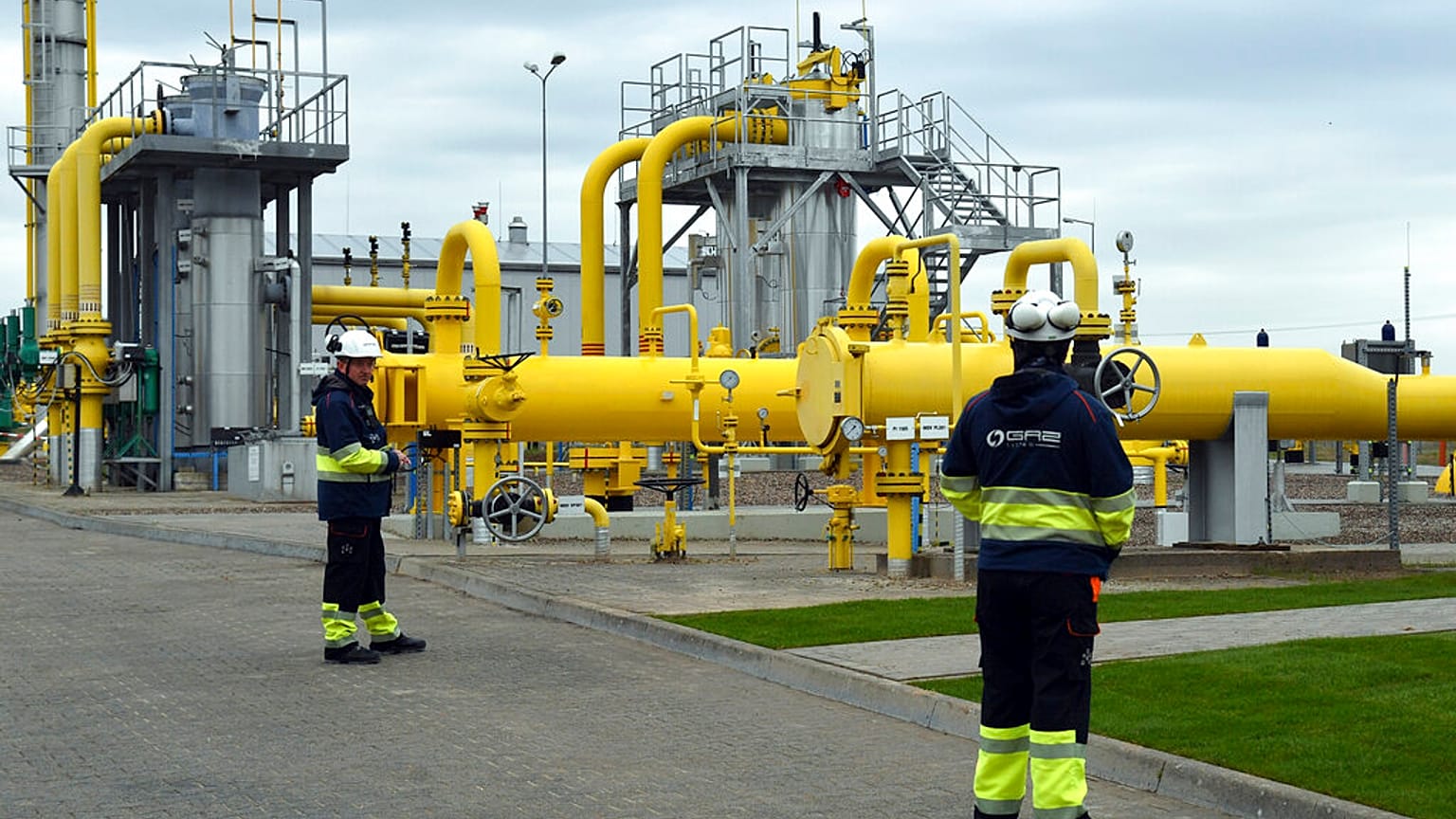 Workers stand near the pipelines during an opening ceremony of the Baltic Pipe in Budno, Poland, Tuesday, Sept. 27, 2022. 
