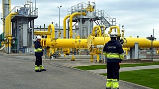 Workers stand near the pipelines during an opening ceremony of the Baltic Pipe in Budno, Poland, Tuesday, Sept. 27, 2022. 