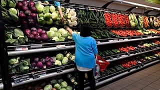 Zöldségeket válogató vásárló egy CBA-ban 2020-ban. 