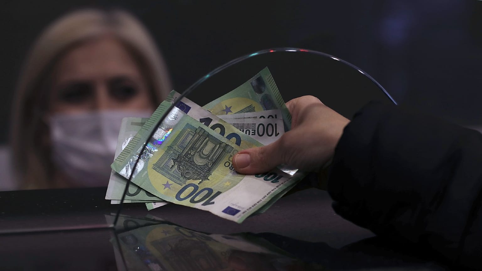 A woman changes Turkish lira for Euros at a currency exchange shop, in Ankara, Turkey, Dec. 16, 2021.