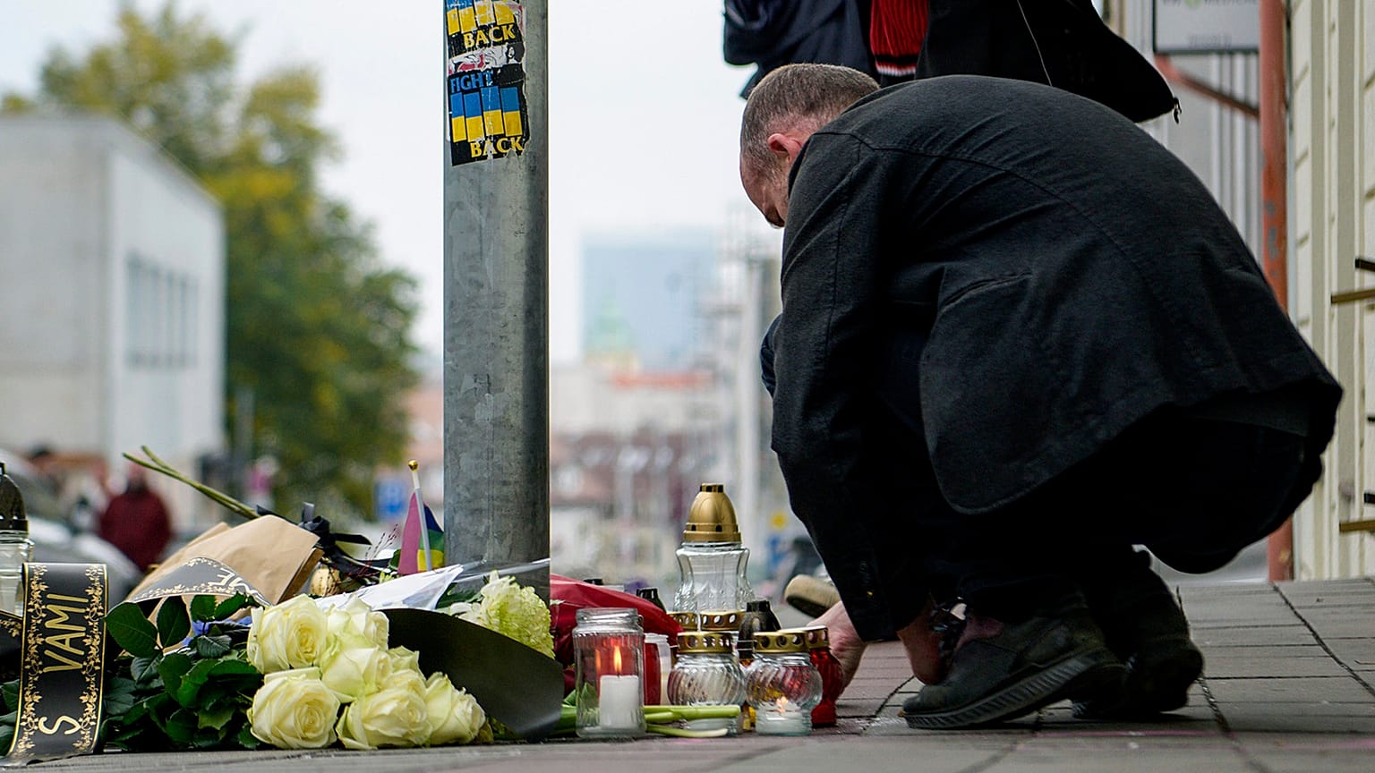 People lay flowers and light candles at the scene of Wednesday's attack on Zamocka Street in Bratislava, 13 October 2022