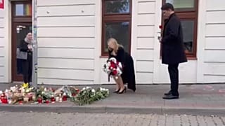 Zuzana Caputova a pozsonyi lövöldözés helyszínén helyez el virágokat