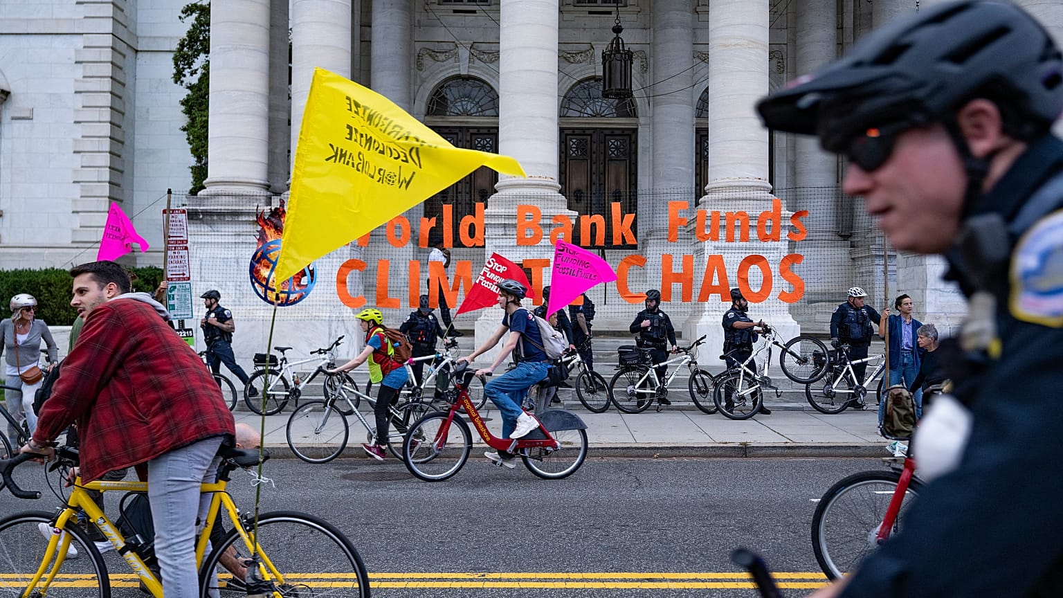 Climate protesters on bicycles block the street outside the International Monetary Fund (IMF) and World Bank Group (WBG) Annual Meeting in Washington, DC.