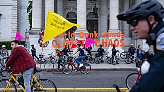 Climate protesters on bicycles block the street outside the International Monetary Fund (IMF) and World Bank Group (WBG) Annual Meeting in Washington, DC.
