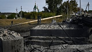 Un homme marche sur un gazoduc au-dessus d'un pont détruit après un bombardement à Bakhmut, en Ukraine - 22.09.2022