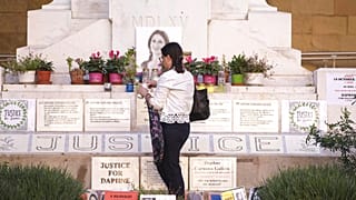 Mandy Mallia, sœur de la défunte journaliste Daphne Caruana Galizia, allume des bougies devant une photo de sa sœur à La Valette, Malte, vendredi 14 octobre 2022