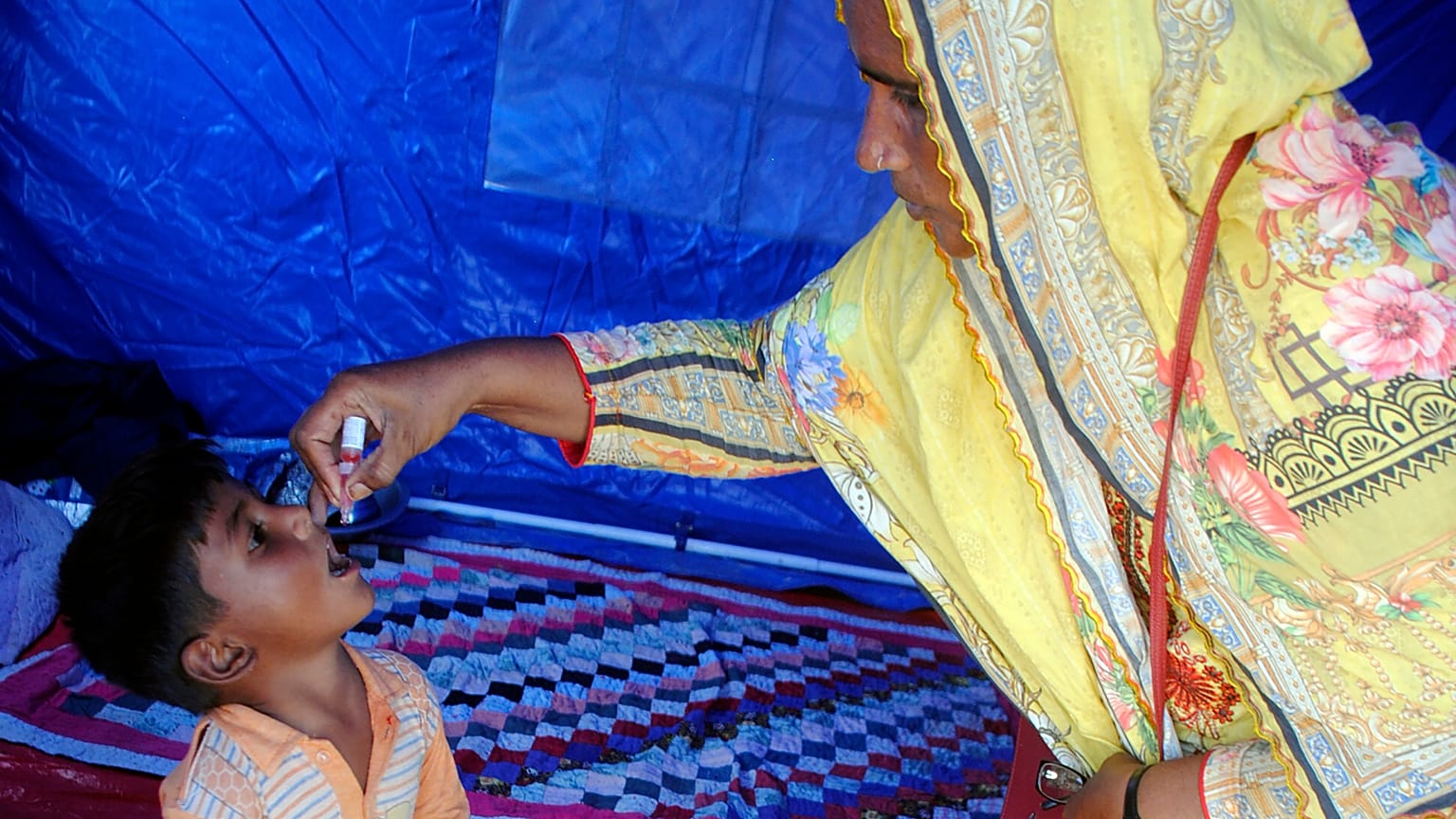 A health worker administers a polio vaccine to a child at a camp in Hyderabad, Pakistan, Tuesday, Sept. 6, 2022.