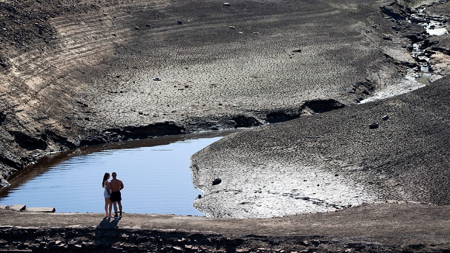 A couple stands on what was an ancient packhorse bridge exposed by low water levels at Baitings Reservoir in Yorkshire, England, Aug. 12, 2022.