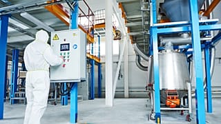 A worker in an industrial chemical factory. The European commission may delay planned reform of its chemical regulation laws. 