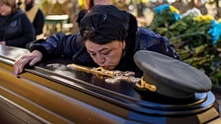 Tatiana Alexeyevna mourns over the coffin of her son Colonel Oleksiy Telizhenko during his funeral in Bucha, 18 October 2022