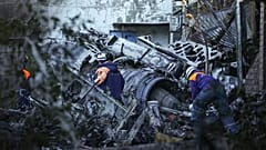 Equipas de socorro examinam partes do avião que se despenhou