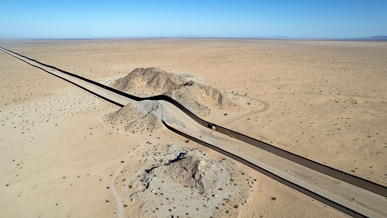 Aerial view of a hill on the dessert crossed by a section of the US - Mexico border wall near San Luis Rio Colorado, Mexico, on September 19, 2022. 