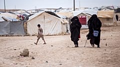 Women walk in the al-Hol camp that houses some 60,000 refugees, including families and supporters of the Islamic State group. 1 May 2021.
