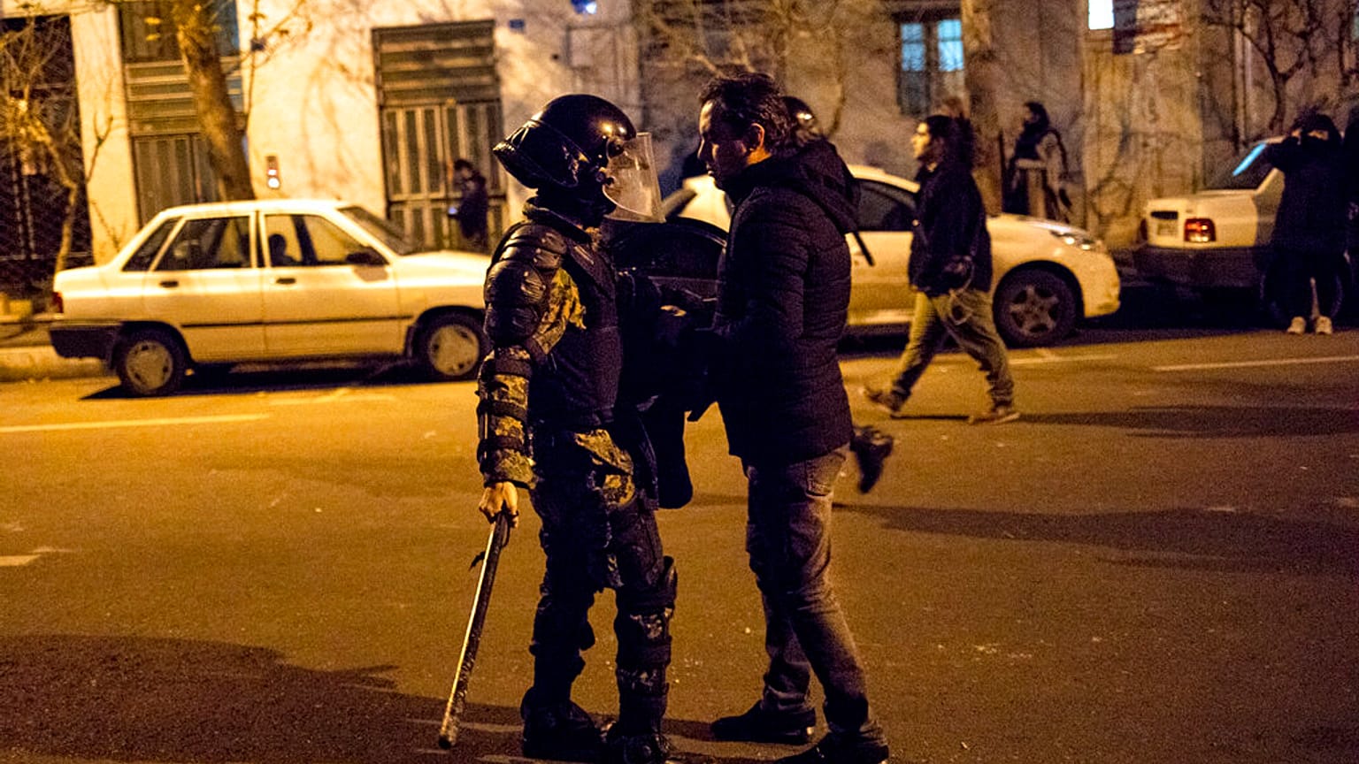 Saturday, Jan. 11, 2020, a protester confronts an Iranian police officer while demonstrators gather in front of Amir Kabir University in Tehran, Iran.