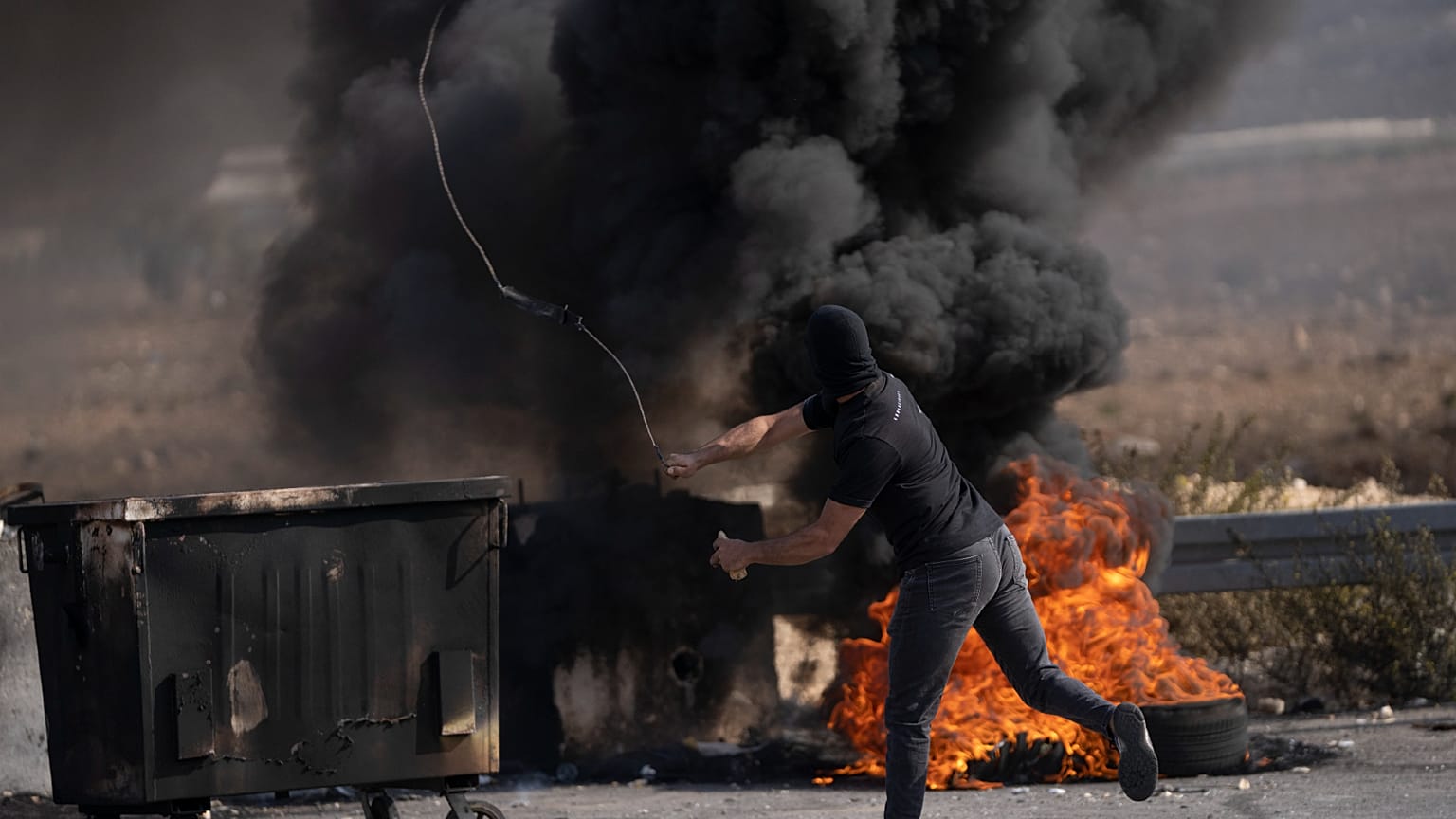 متظاهر فلسطيني يستخدم مقلاعًا خلال اشتباكات مع قوات الجيش الإسرائيلي في مدينة رام الله بالضفة الغربية.