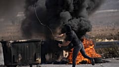 متظاهر فلسطيني يستخدم مقلاعًا خلال اشتباكات مع قوات الجيش الإسرائيلي في مدينة رام الله بالضفة الغربية.