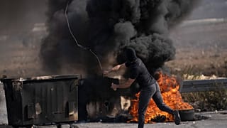 متظاهر فلسطيني يستخدم مقلاعًا خلال اشتباكات مع قوات الجيش الإسرائيلي في مدينة رام الله بالضفة الغربية.